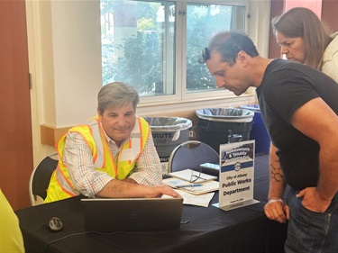 Three people looking at a laptop screen at the Homeowners & Tenants Resource Fair